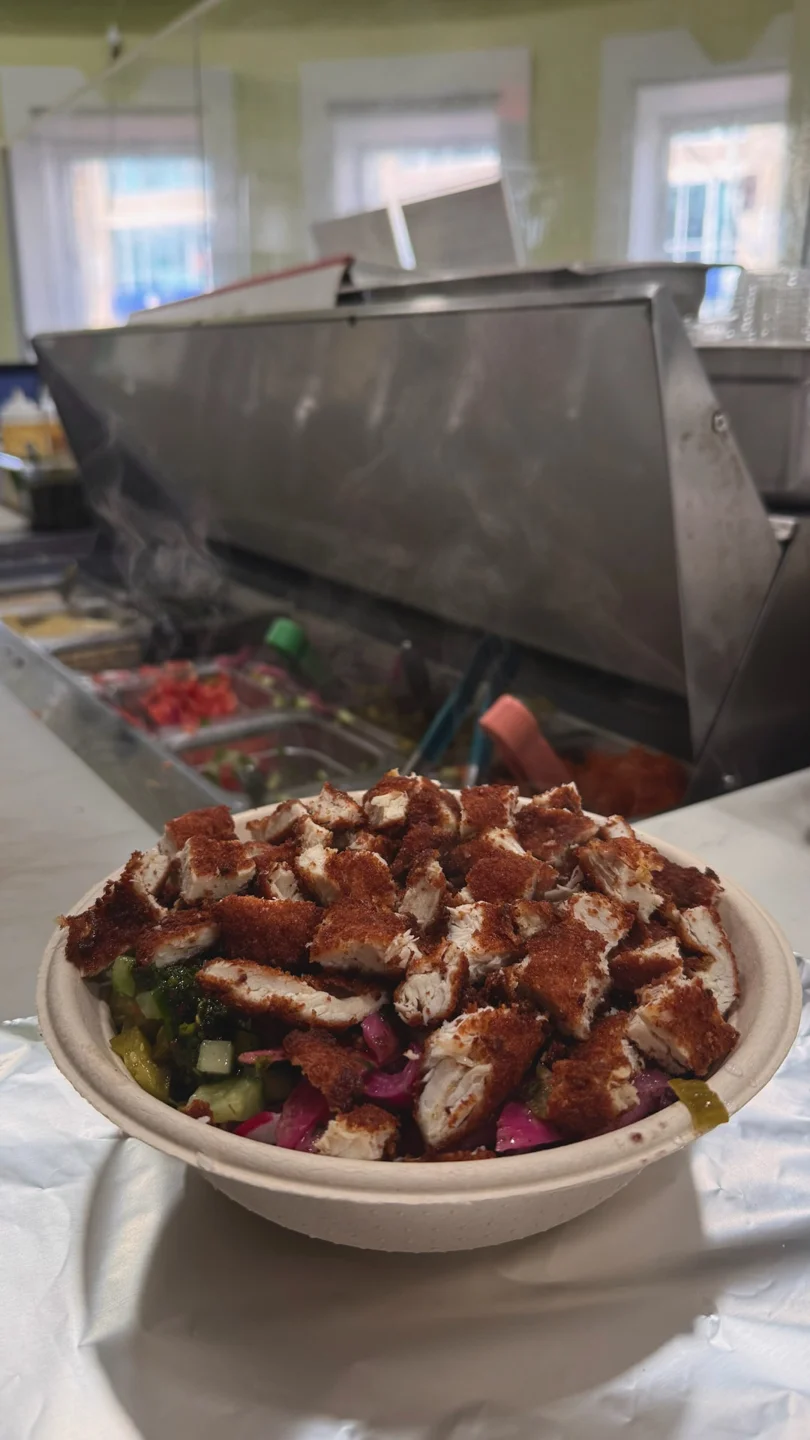Crispy chicken bowl with zhoug and pickles at the steam table