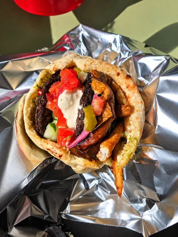 Stuffed pita with falafel, roasted eggplant, pickled cabbage and tahini