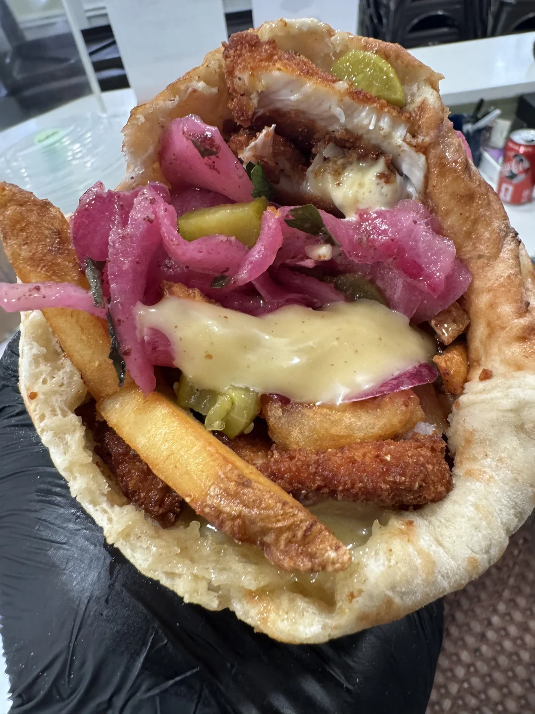 Stuffed pita with crispy chicken, fries, pickled red onions, pickles and garlic sauce